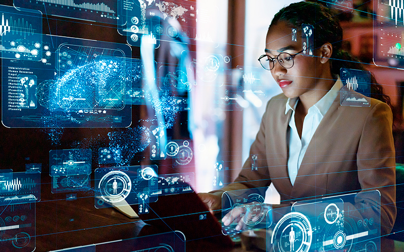 Young woman in a suit at a computer with data holograms around her