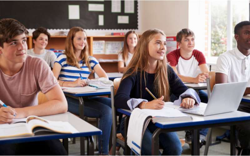 Group of teenagers in a classroom all at desks looking forward