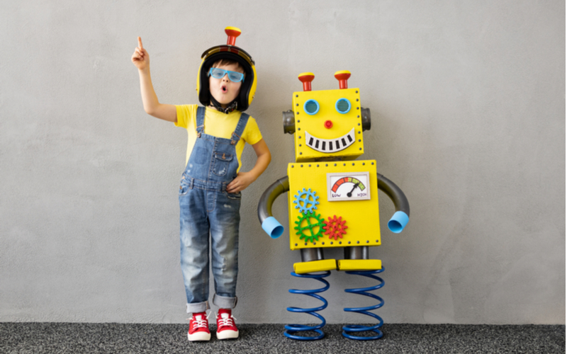 Young boy dressed as a robot next to a lifesized robot toy