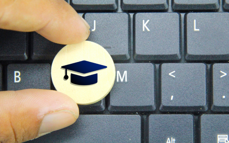 hand holding a round stick with a graduation hat icon. the concept of graduation. Education Concept