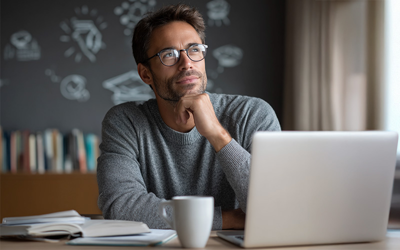 Mid-career professional researching postgraduate study options at home.